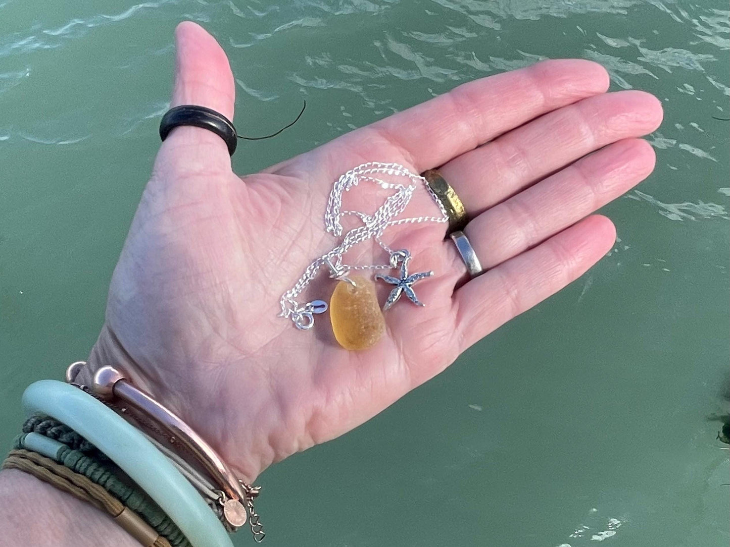 Eco friendly sea glass necklace on a sterling silver chain showcasing a little starfis. Starfish pendant, octopus necklace, eco jewellery