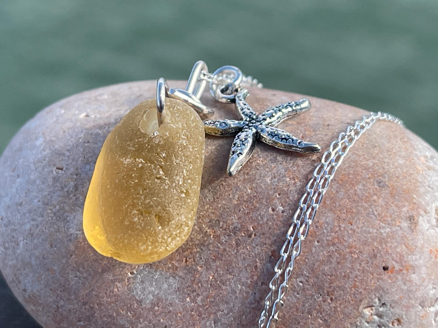 Eco friendly sea glass necklace on a sterling silver chain showcasing a little starfis. Starfish pendant, octopus necklace, eco jewellery