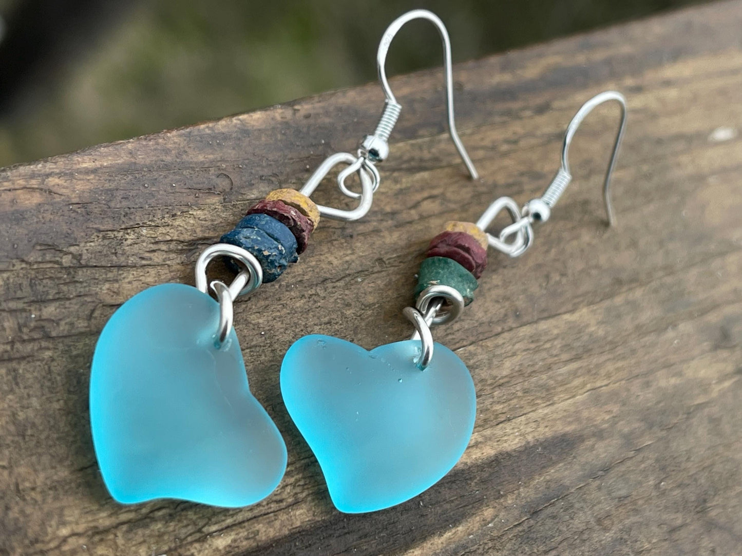 Sea glass heart earrings iron recycled sterling silver. Eco conscious jewellery. Ethical jewellery. Blue sea glass hearts. Handmade earrings