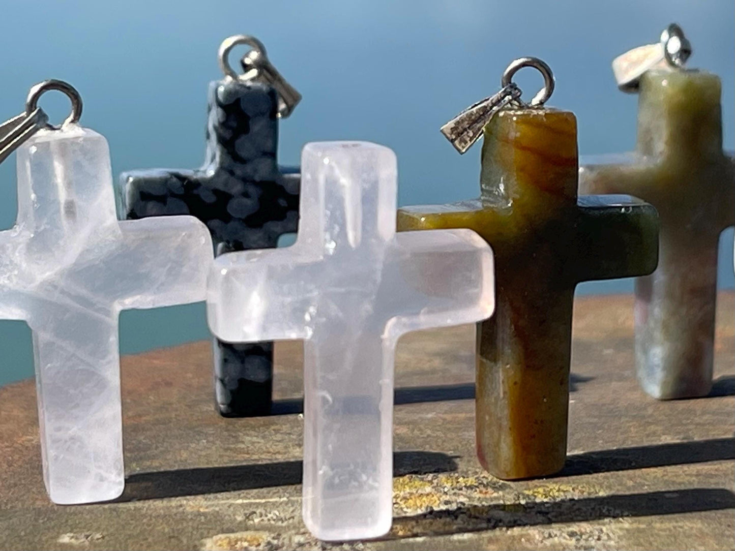 6 gemstone crosses. Rose quartz, obsidian, quartz and more. One without clasp. Jewellery charms, gemstone charms. Crosses.