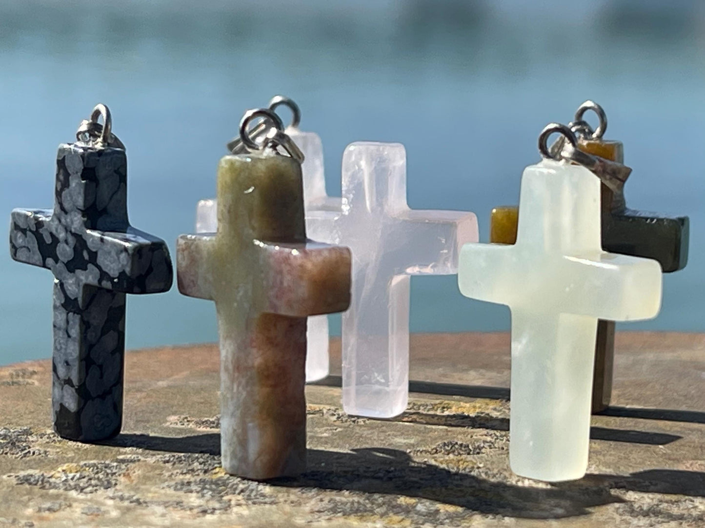 6 gemstone crosses. Rose quartz, obsidian, quartz and more. One without clasp. Jewellery charms, gemstone charms. Crosses.