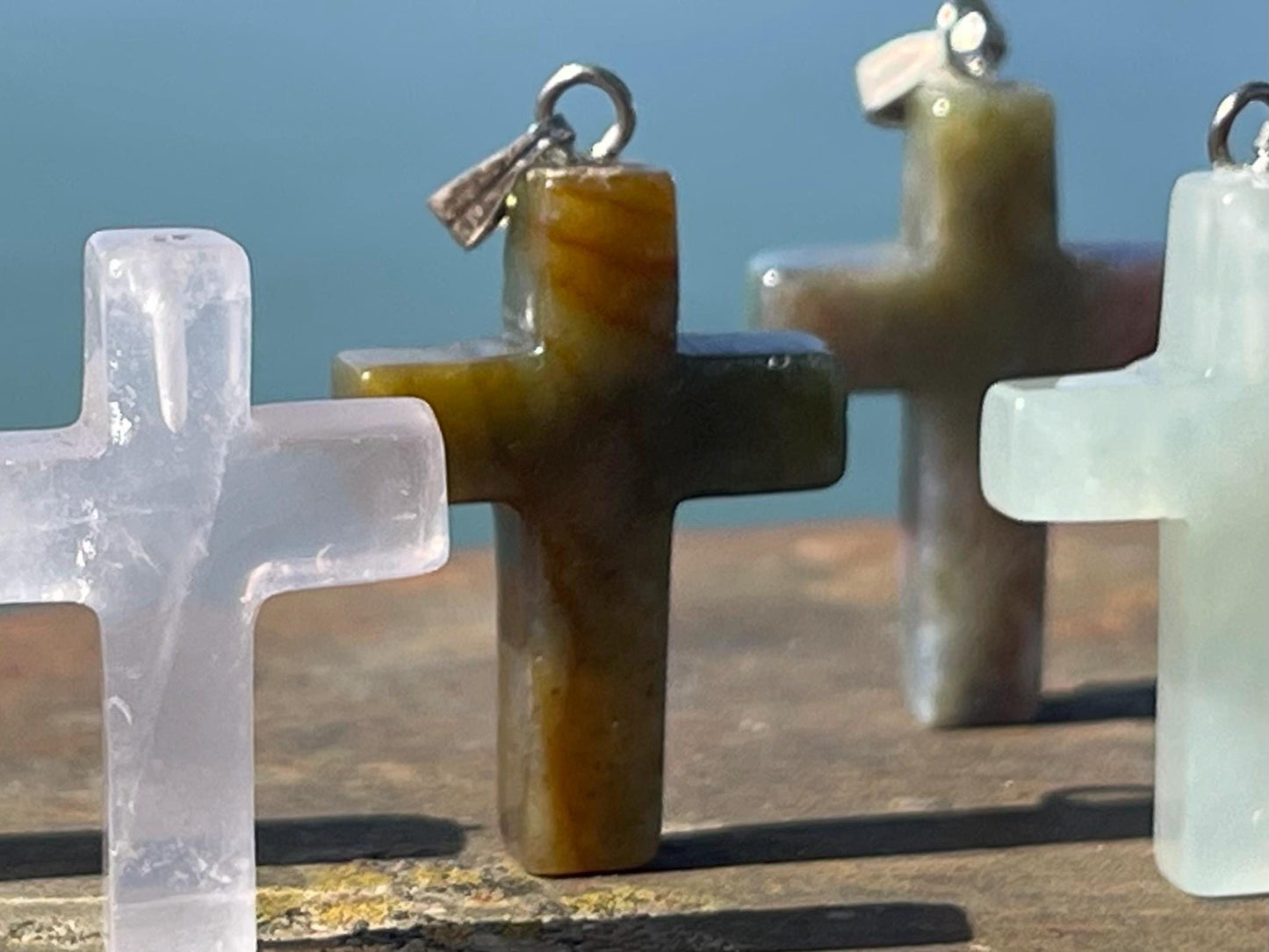 6 gemstone crosses. Rose quartz, obsidian, quartz and more. One without clasp. Jewellery charms, gemstone charms. Crosses.