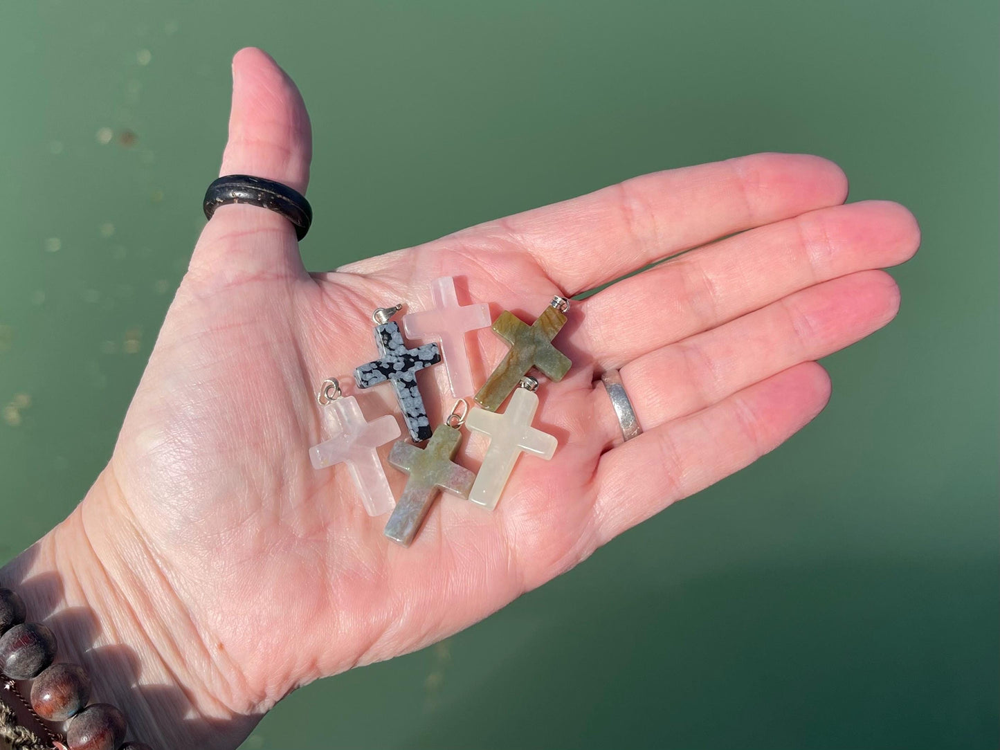 6 gemstone crosses. Rose quartz, obsidian, quartz and more. One without clasp. Jewellery charms, gemstone charms. Crosses.