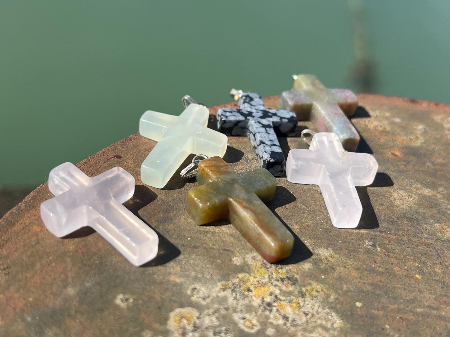 6 gemstone crosses. Rose quartz, obsidian, quartz and more. One without clasp. Jewellery charms, gemstone charms. Crosses.