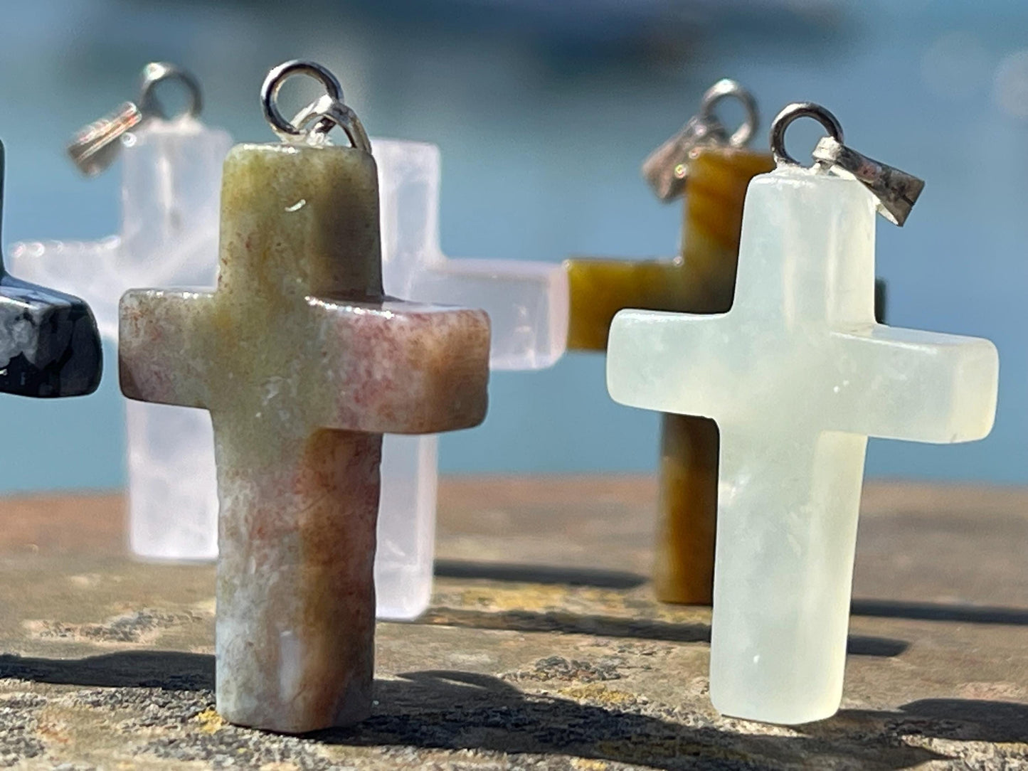 6 gemstone crosses. Rose quartz, obsidian, quartz and more. One without clasp. Jewellery charms, gemstone charms. Crosses.