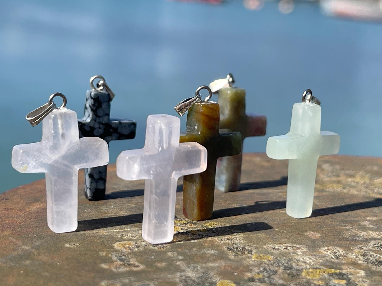 6 gemstone crosses. Rose quartz, obsidian, quartz and more. One without clasp. Jewellery charms, gemstone charms. Crosses.