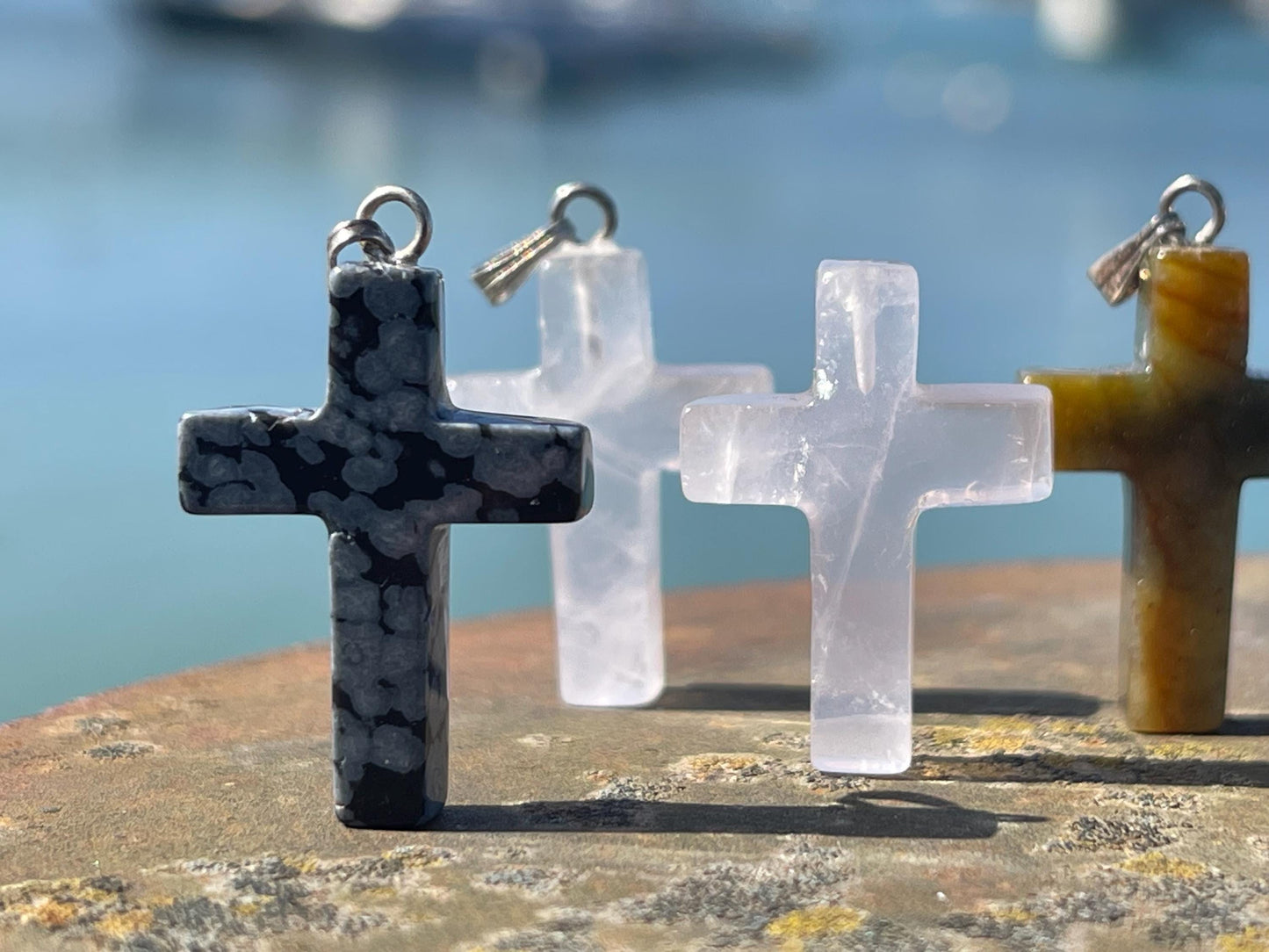 6 gemstone crosses. Rose quartz, obsidian, quartz and more. One without clasp. Jewellery charms, gemstone charms. Crosses.