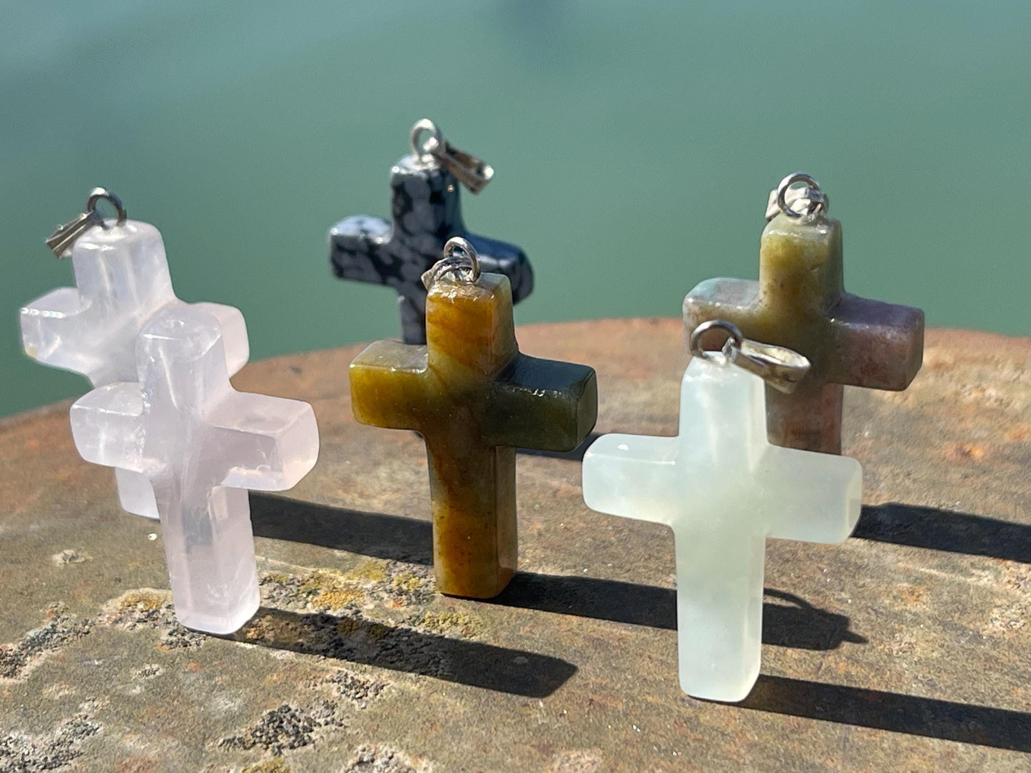 6 gemstone crosses. Rose quartz, obsidian, quartz and more. One without clasp. Jewellery charms, gemstone charms. Crosses.