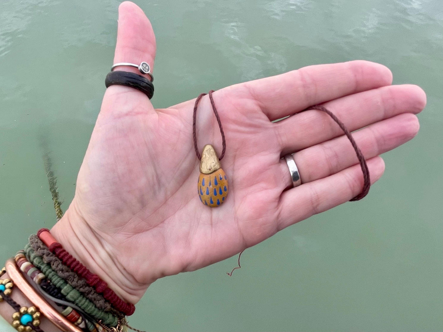 Pebble pendants. Painted pebble necklaces. Hand painted eco friendly necklaces. Eco friendly jewellery. Ethical handmade jewellery.