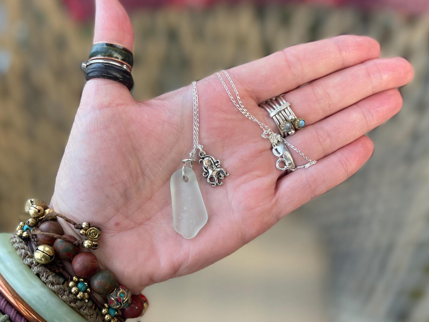 Eco friendly sea glass necklace on a sterling silver chain showcasing a little octopus. Octopus pendant, eco friendly jewellery.