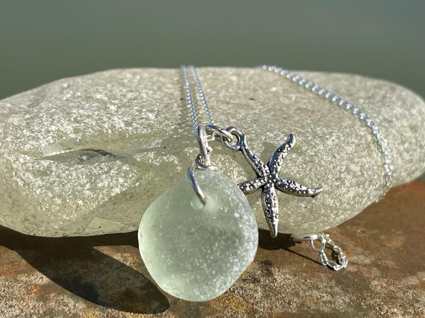 Eco friendly white sea glass necklace on a sterling silver chain showcasing a little starfish. Starfish pendant, eco friendly jewellery.