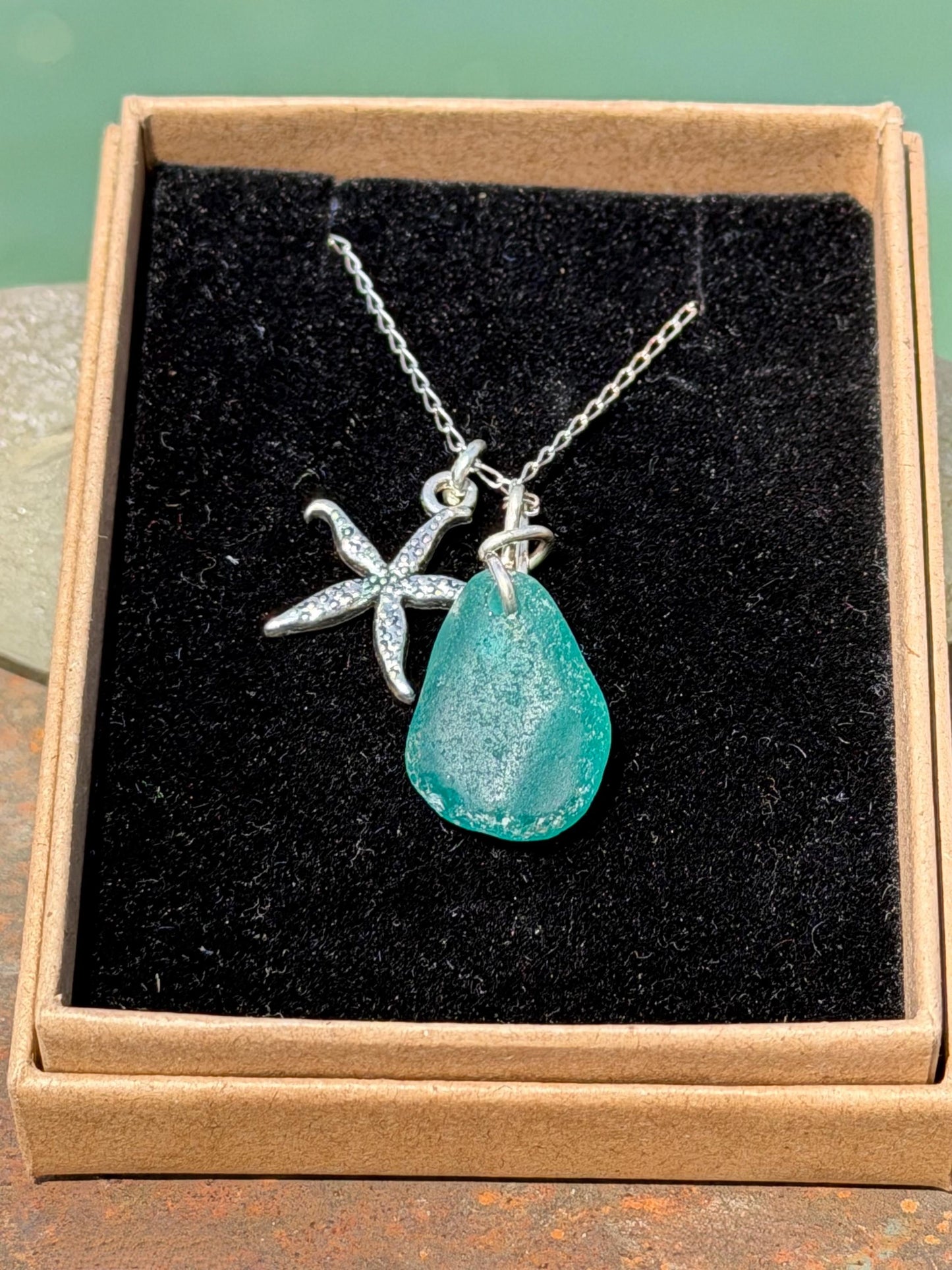 Eco friendly turquoise sea glass necklace on a sterling silver chain showcasing a little starfish. Starfish pendant, eco friendly jewellery.