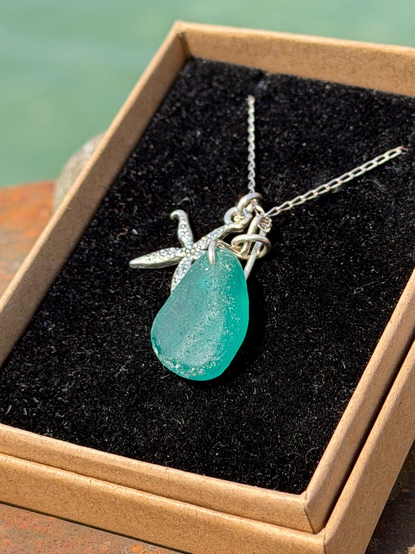 Eco friendly turquoise sea glass necklace on a sterling silver chain showcasing a little starfish. Starfish pendant, eco friendly jewellery.