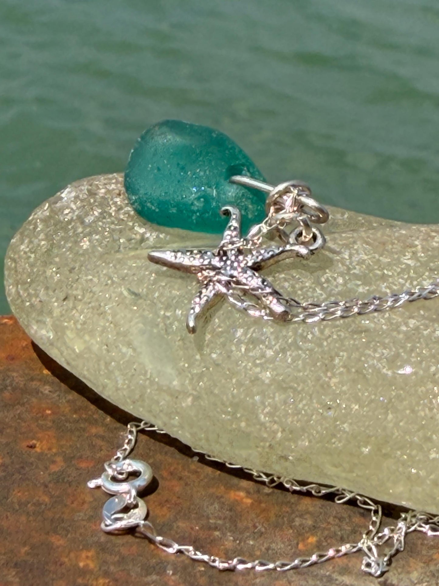 Eco friendly turquoise sea glass necklace on a sterling silver chain showcasing a little starfish. Starfish pendant, eco friendly jewellery.